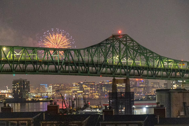 Fireworks over Boston Harbor as seen from behind the Tobin Bridge