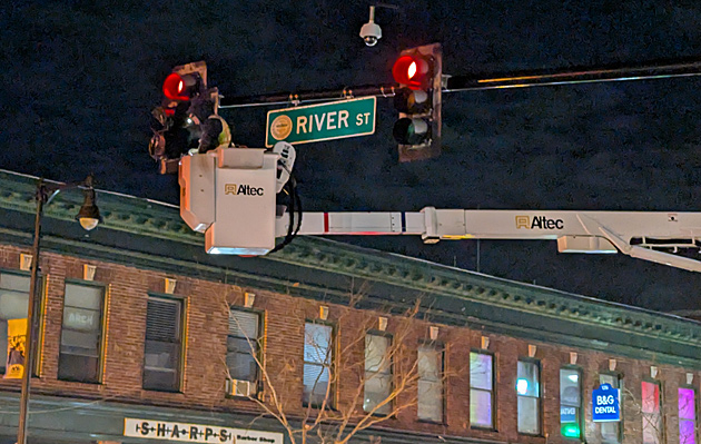 Worker in bucket removing tape covering traffic lights at the intersection